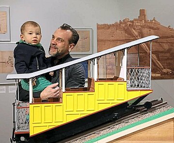 Die historische Turmbergbahn ist als Modell ein Blickfang im Pfinzgaumuseum; Martin Sprißler und der kleine Ben haben sie gleich entdeckt