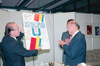 Sportbürgermeister Norbert Vöhringer überreicht Oberbürgermeister Prof. Gerhard Seiler eine Metalltafel mit dem Logo der World Games und Unterschriften des Organisationskomitees, 30. Juli 1989